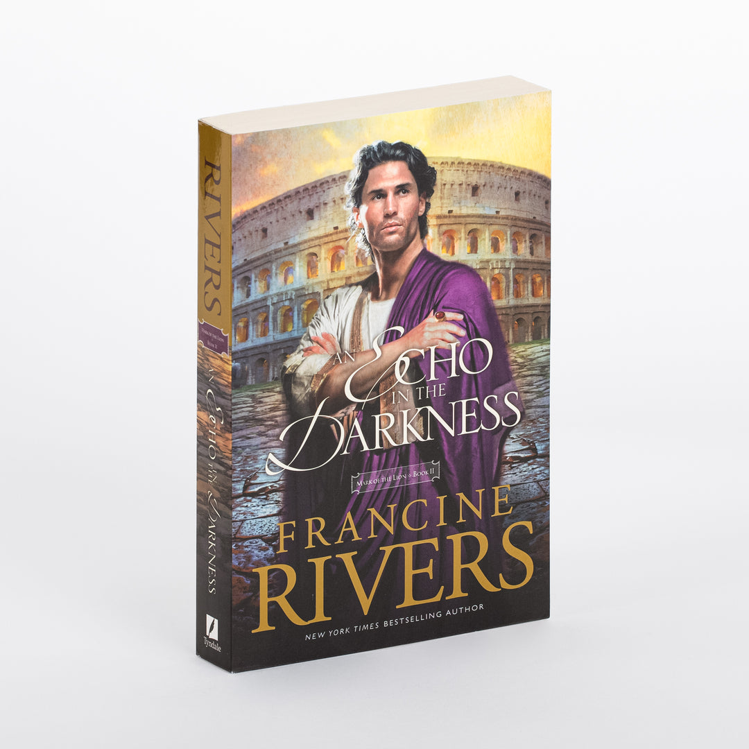Product photo of the paperback novel An Echo in the Darkness by Francine Rivers, Mark of the Lion Series Book 2, angled to show both the front cover and spine. The cover shows a young man with dark curly hair and a short beard, arms crossed, wearing a white tunic and purple toga, standing before the ancient Roman Colosseum under a glowing golden-orange sky. Title appears in white script and block lettering, with FRANCINE RIVERS in bold gold letters below.