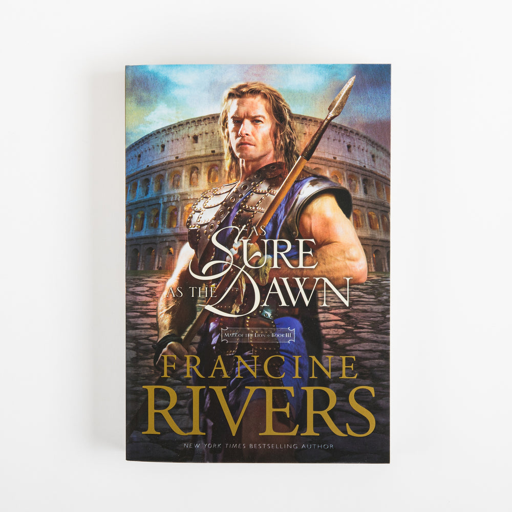 Front cover of As Sure as the Dawn (Mark of the Lion, Book 3) by Francine Rivers. A muscular, bare-armed Roman warrior with long hair grips a spear, standing on stone pavement in front of the ancient Colosseum beneath a blue sky. The title 'As Sure as the Dawn' is set in white cursive script across the center, with a small purple Mark of the Lion Book III series tag beneath it, and the author's name 'Francine Rivers' in large gold letters at the bottom above 'New York Times bestselling author.'
