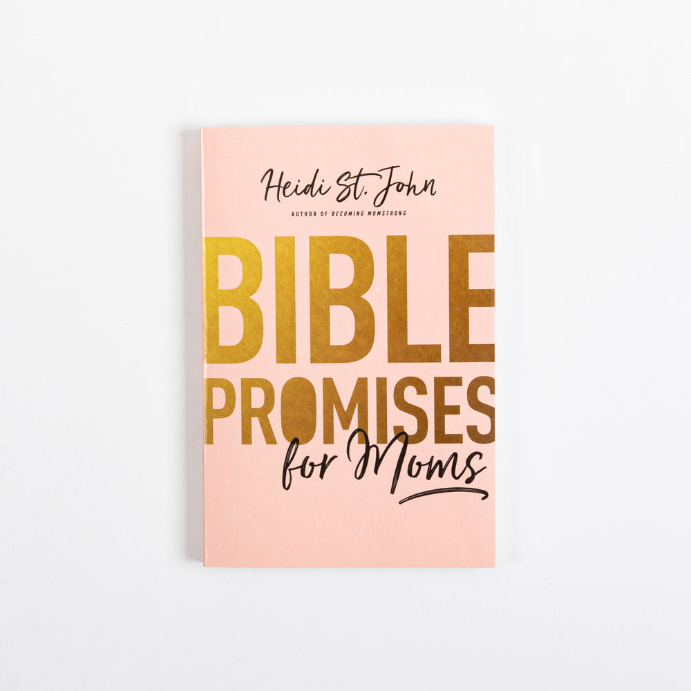 Straight-on front cover of the blush-pink paperback book 'Bible Promises for Moms' by Heidi St. John, photographed flat against a white background. The author's name appears in cursive at the top with 'Author of Becoming Momstrong' beneath it. Below that, the title 'BIBLE PROMISES' is printed in large bold gold-foil block letters, with 'for Moms' written underneath in matching gold cursive script and underlined with a decorative swoosh.