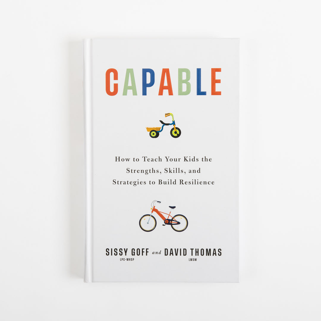 Front cover of Capable by Sissy Goff and David Thomas: a white hardcover with the title in red, green, and blue letters, a small tricycle icon below the title, an orange bicycle icon lower on the cover, and the subtitle How to Teach Your Kids the Strengths, Skills, and Strategies to Build Resilience above the authors&
