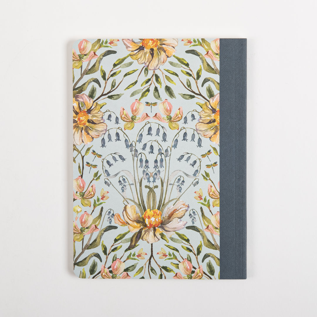 Flat, straight-on back cover of the Humility scripture journal showing the same watercolor peach peony and blue bellflower pattern as the front but without title text, with the slate-blue cloth spine visible at the right edge.