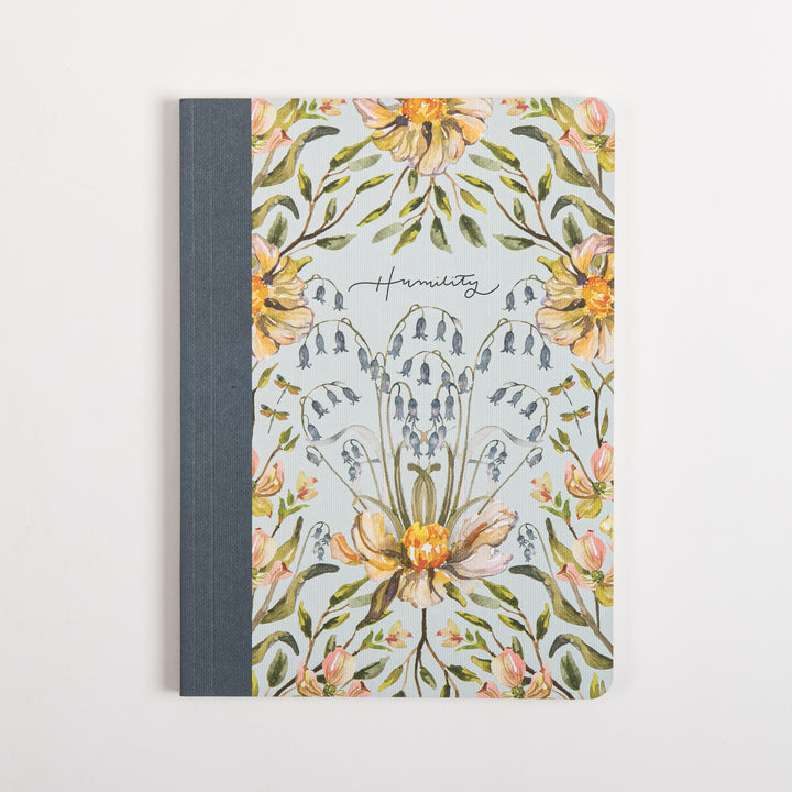 Flat, straight-on front cover of the Humility scripture journal with a light blue background, watercolor peach peonies, blue bellflowers, and dragonflies framing a cursive &