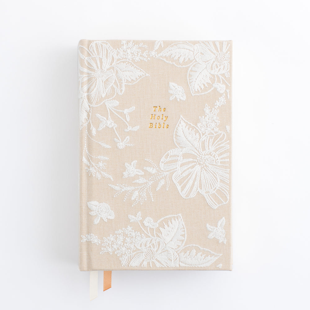 NLT Compact Bible Casablanca Theme Hosanna Revival – tan linen hardcover with white embroidered butterfly and floral pattern across full cover The Holy Bible in gold lettering at center and peach ribbon bookmark – front cover view