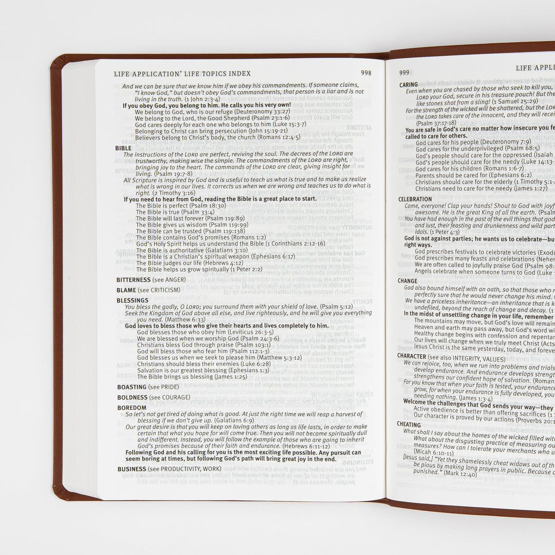 Open two-page spread of the Life Application Life Topics Index in the back matter, showing small-print alphabetical topic entries such as Bible, Blessings, Boredom, Caring, Celebration, and Change with related Bible verse references, page numbers 998 and 999.