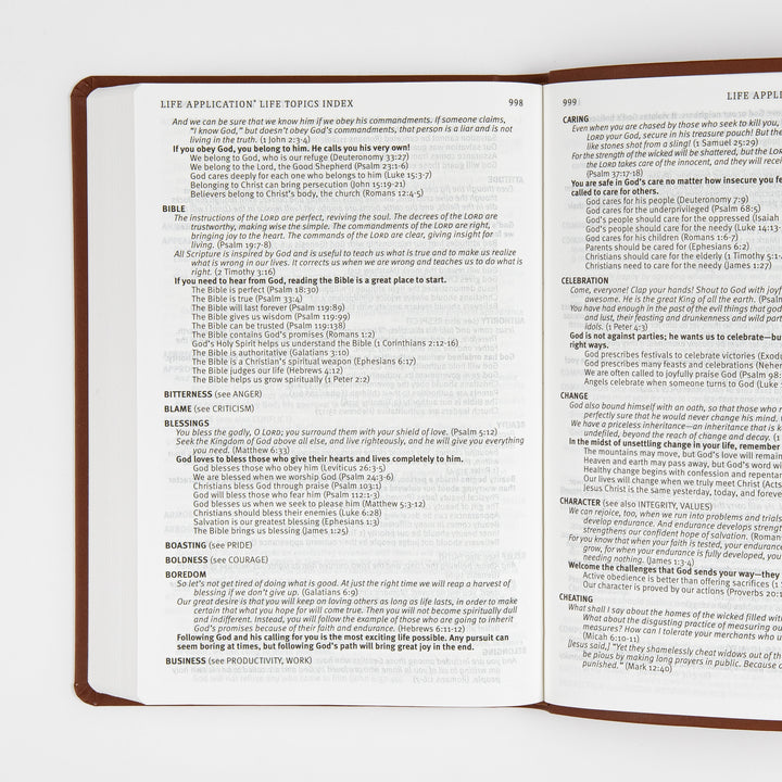 Open two-page spread of the Life Application Life Topics Index in the back matter, showing small-print alphabetical topic entries such as Bible, Blessings, Boredom, Caring, Celebration, and Change with related Bible verse references, page numbers 998 and 999.