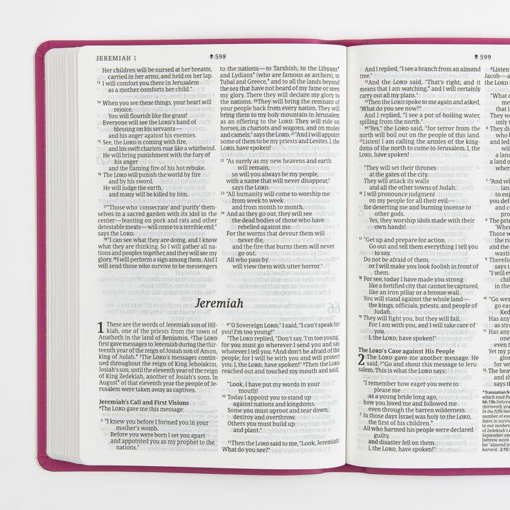 Open Bible interior spread transitioning from the end of Jeremiah 1 into the start of Jeremiah 2, two columns of large-print black text per page with italic section headings and the italic book title Jeremiah centered above the text block; pink cover edges frame the pages.