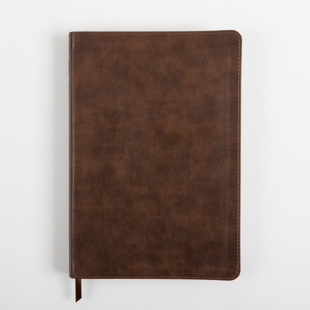 Rustic brown leatherlike cover of the NLT Large Print Thinline Reference Bible, lying flat and viewed from above, showing the textured leatherlike grain, stitched edges, and a brown ribbon marker at the bottom edge.