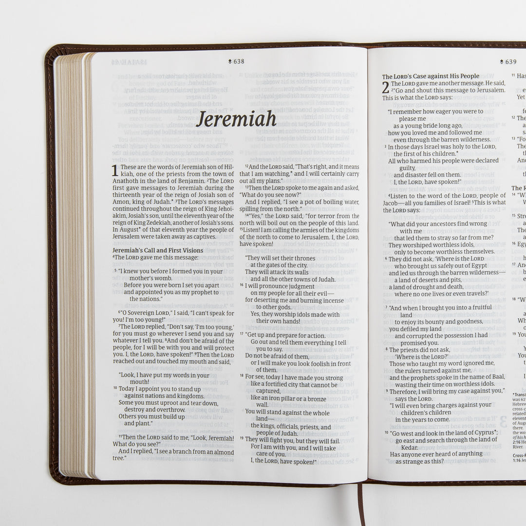 Open Bible spread showing the large-print italic title page for the book of Jeremiah with chapter 1 and the start of chapter 2, a brown ribbon marker hanging from the spine, and cross-references at the bottom of the page.