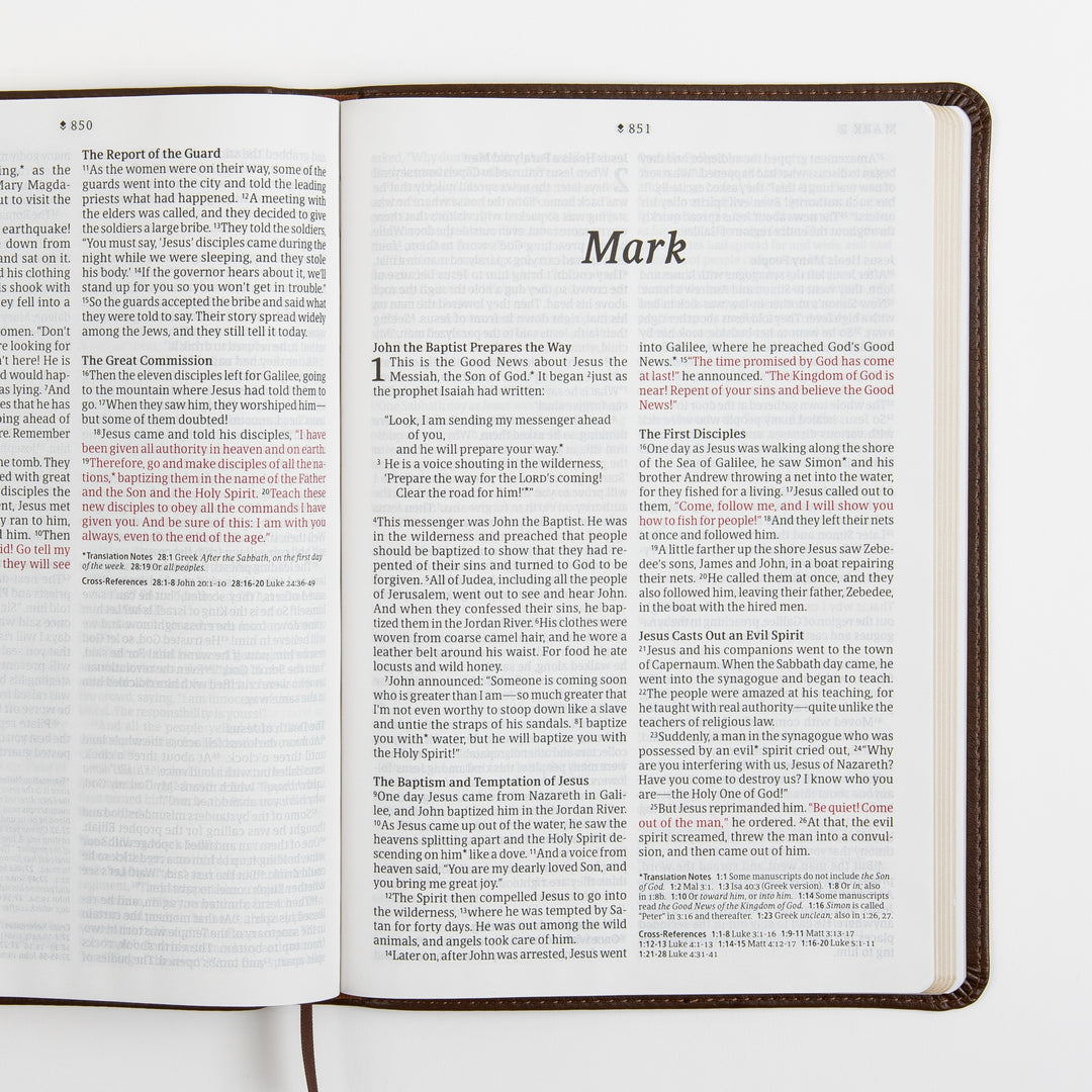 Open Bible spread showing the end of Matthew and the title page for the Gospel of Mark, with the words of Jesus printed in red, large-print two-column text, and translation notes and cross-references at the bottom.