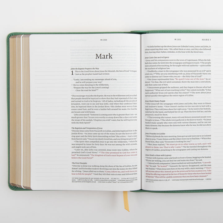 Open interior spread of the NLT Wide Margin Bible showing the Gospel of Mark title page and the start of chapter 1 on the left page and the continuation of Mark 1 on the right, with the words of Jesus printed in red and wide blank ruled margins on both sides for handwritten notes.