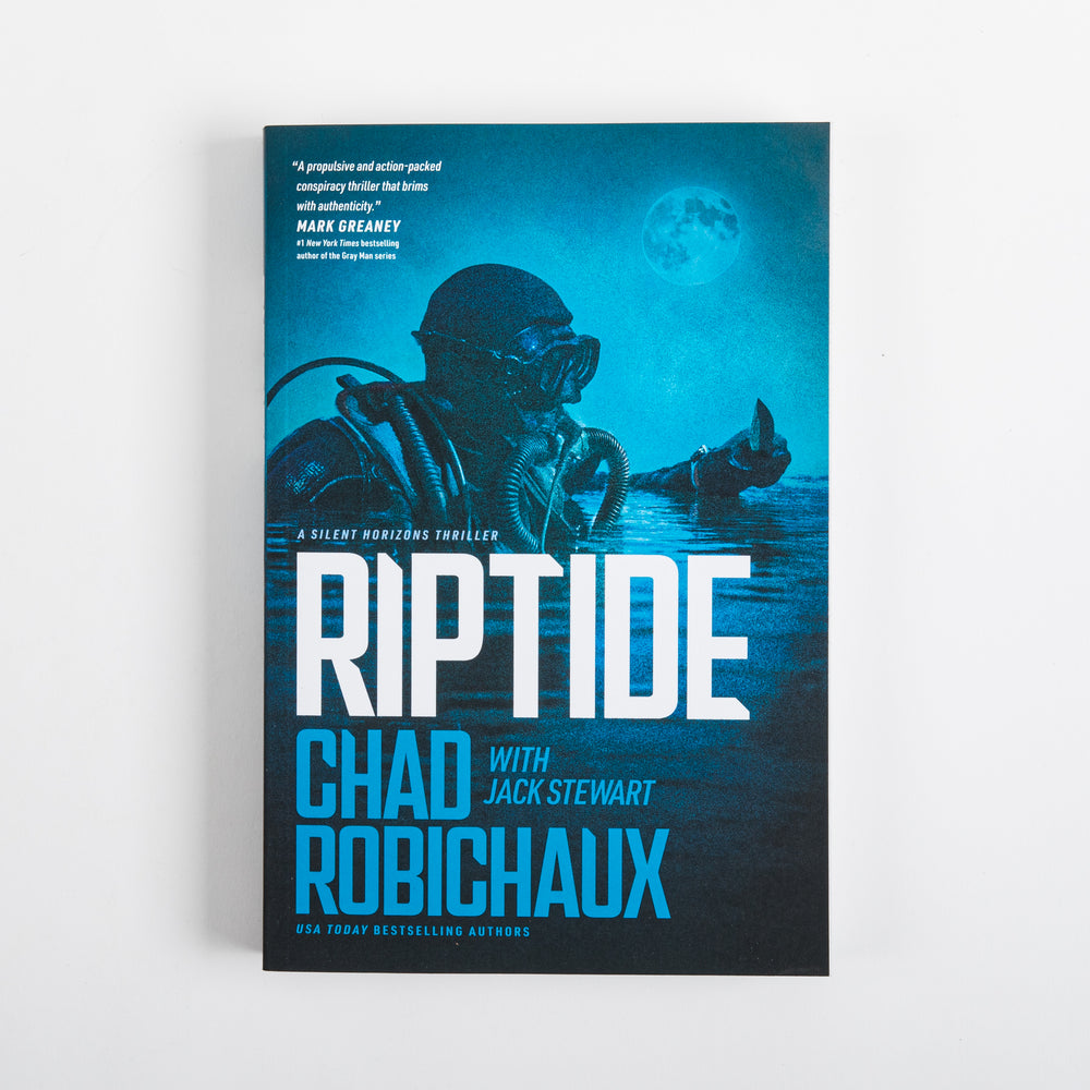 Straight-on view of the front cover of 'Riptide: A Silent Horizons Novel' by Chad Robichaux with Jack Stewart. Dark teal-blue nighttime ocean scene: a masked tactical diver surfaces under a glowing full moon, a hand breaking the water nearby. A blurb quote appears near the top; 'A SILENT HORIZONS THRILLER' sits above the large white/blue 'RIPTIDE' title, followed by the authors' names in blue and 'USA TODAY BESTSELLING AUTHORS.' Plain light gray background.