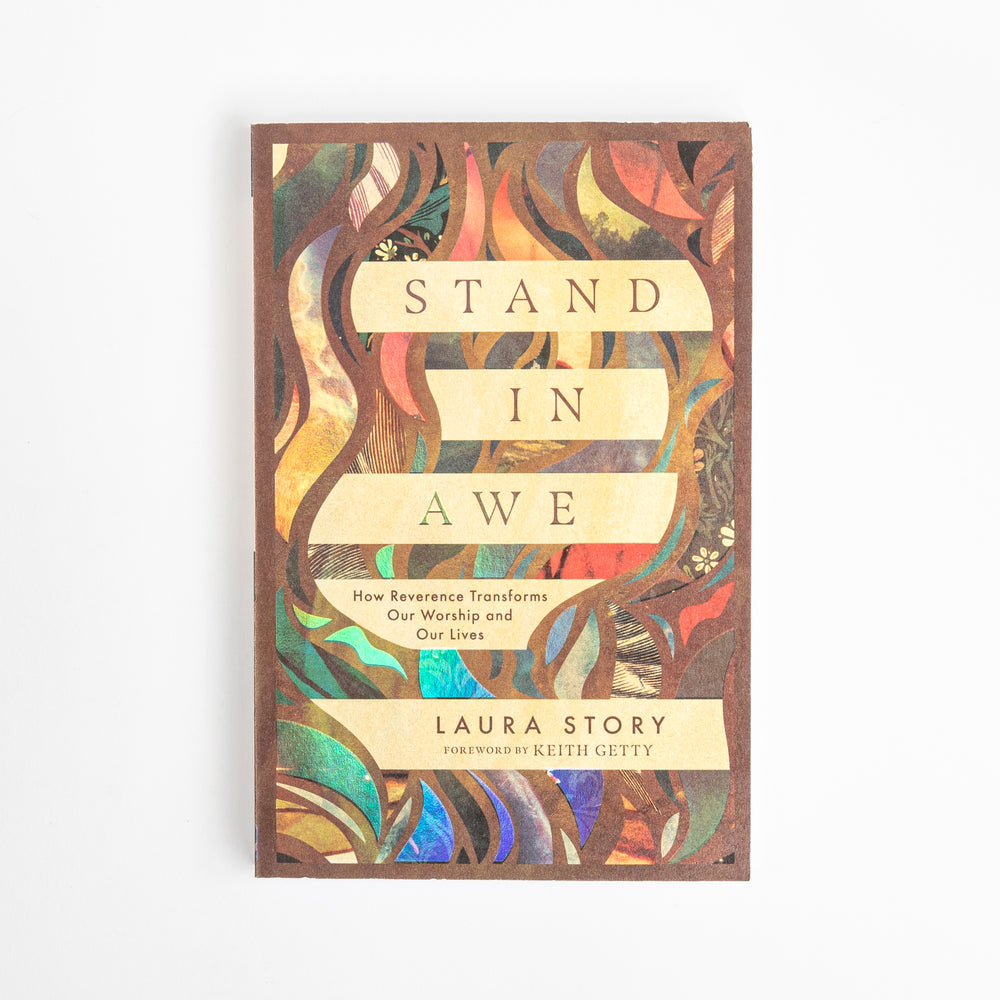 Front cover of the paperback book 'Stand in Awe: How Reverence Transforms Our Worship and Our Lives' by Laura Story, foreword by Keith Getty, shown flat against a white background. The cover design is a colorful abstract pattern of vines and leaves in teal, orange, purple, and gold, with the title on cream ribbon banners.
