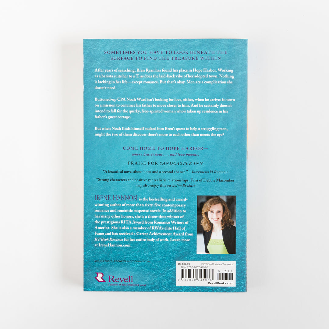 Back cover of Sunrise Reef by Irene Hannon on a teal textured background, with white body text giving the synopsis about barista Bren Ryan and CPA Noah Ward in Hope Harbor, a review blurb for Sandcastle Inn, an author photo of Irene Hannon in a black jacket, the Revell publisher logo, and a barcode with price and ISBN.