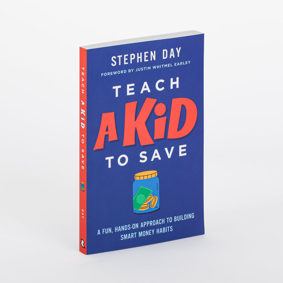 Angled product shot of the paperback book Teach a Kid to Save by Stephen Day, foreword by Justin Whitmel Earley. Navy blue cover with bold red 'A KID' text, white 'TEACH' and 'TO SAVE' lettering, and an illustration of a glass money jar filled with coins and cash. Subtitle reads 'A Fun, Hands-On Approach to Building Smart Money Habits.'