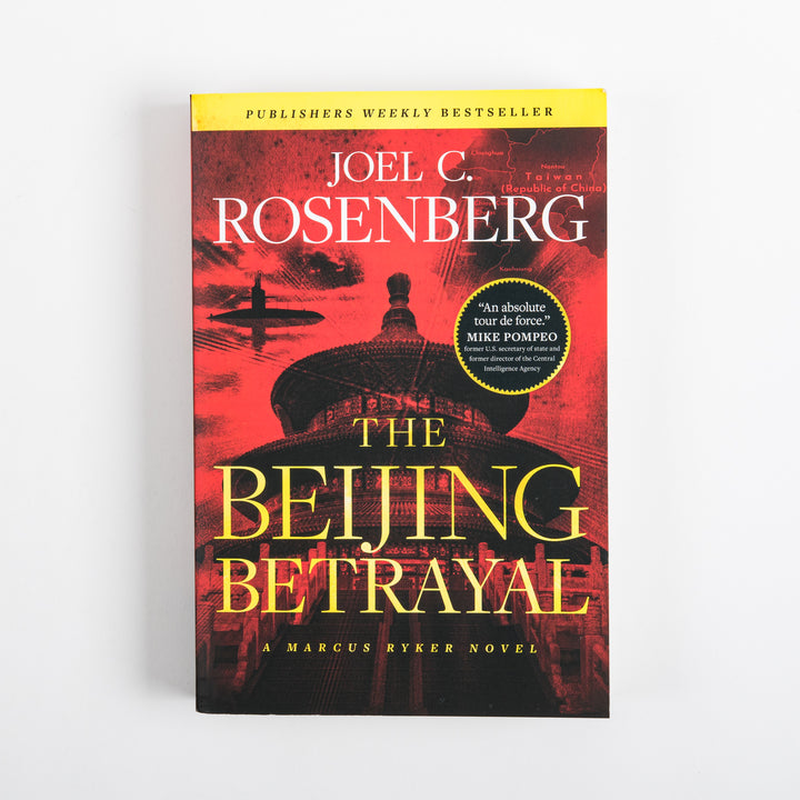 Front cover of The Beijing Betrayal, a Marcus Ryker thriller by Joel C. Rosenberg, photographed flat against a white background. The artwork shows a red-toned silhouette of Beijing&