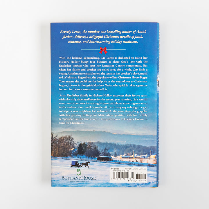 Back cover of The Christmas House by Beverly Lewis, with white plot summary text on a blue background above a snowy Lancaster County photo of a horse-drawn buggy on a farm road, plus the Bethany House logo and barcode.
