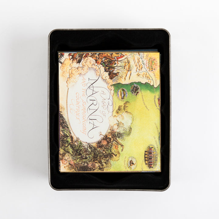 Overhead view into the tin case showing the folded illustrated map tucked inside, its visible portion reading &