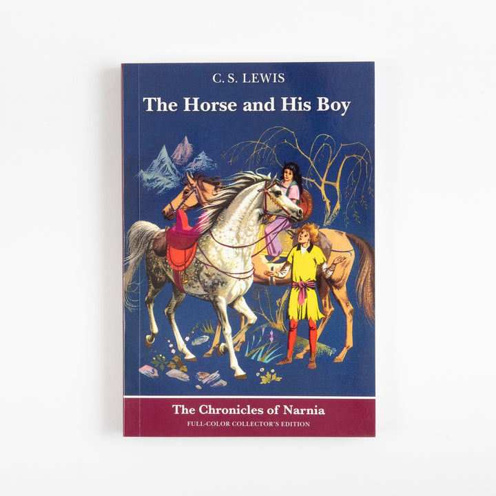 Front cover of the full-color paperback edition of The Horse and His Boy, showing a boy in yellow beside two talking horses, a gray horse and a tan horse carrying a girl, against a dark blue mountain background.