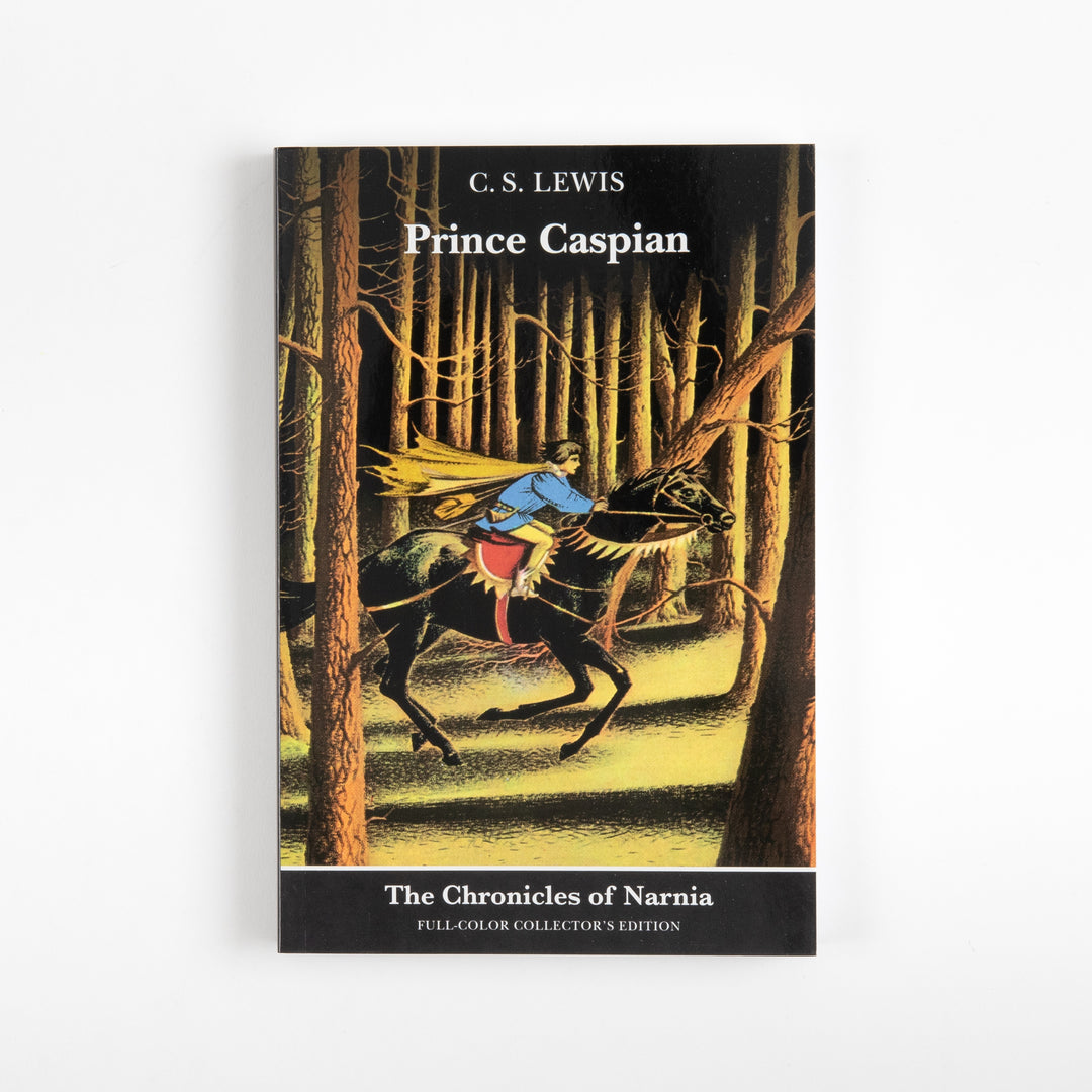 Front cover of the full-color paperback edition of Prince Caspian, showing a caped rider on a black horse galloping through a dark pine forest.