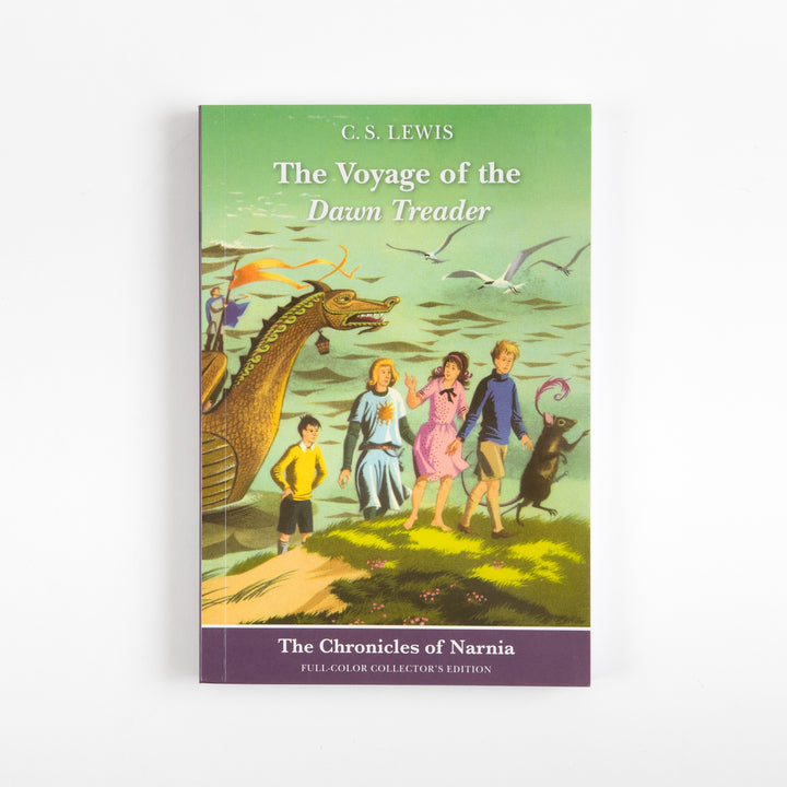 Front cover of the full-color paperback edition of The Voyage of the Dawn Treader, showing four children and a sword-wielding mouse standing on a grassy shore beside the golden dragon-headed ship.