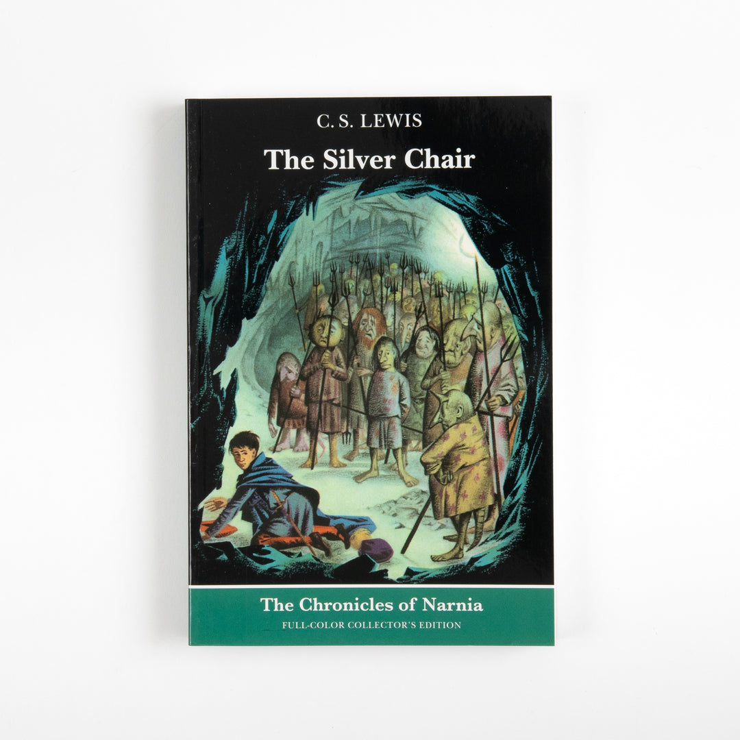 Front cover of the full-color paperback edition of The Silver Chair, showing a boy seated on the ground inside an icy cave, surrounded by a crowd of gnome-like Earthmen holding spears.