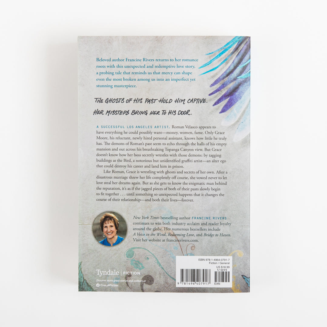 Back cover of The Masterpiece by Francine Rivers on a matching gray textured background, with the teal and purple painted wing continuing into the upper right corner. Blue italic praise text and a black handwritten-style tagline read: The ghosts of his past hold him captive. Her missteps bring her to his door. Below is a synopsis about artist Roman Velasco and his assistant Grace Moore, a round author photo of Francine Rivers, the Tyndale Fiction logo, and a barcode with price sticker.