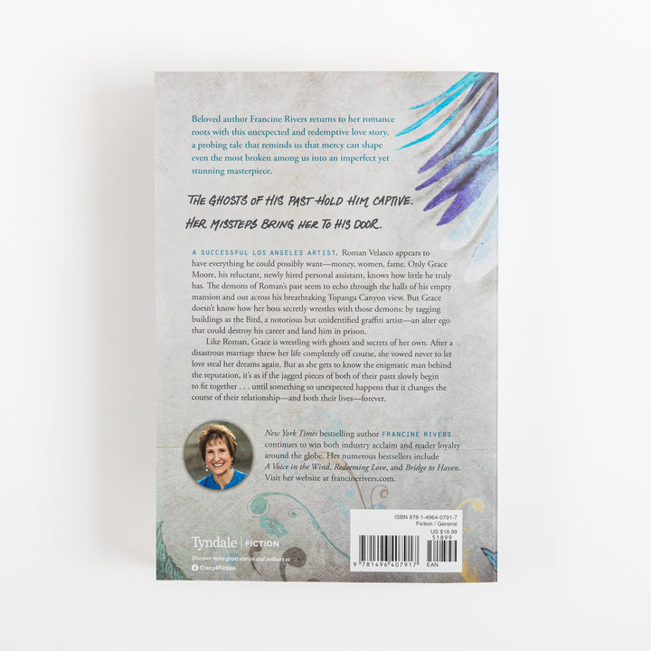 Back cover of The Masterpiece by Francine Rivers on a matching gray textured background, with the teal and purple painted wing continuing into the upper right corner. Blue italic praise text and a black handwritten-style tagline read: The ghosts of his past hold him captive. Her missteps bring her to his door. Below is a synopsis about artist Roman Velasco and his assistant Grace Moore, a round author photo of Francine Rivers, the Tyndale Fiction logo, and a barcode with price sticker.
