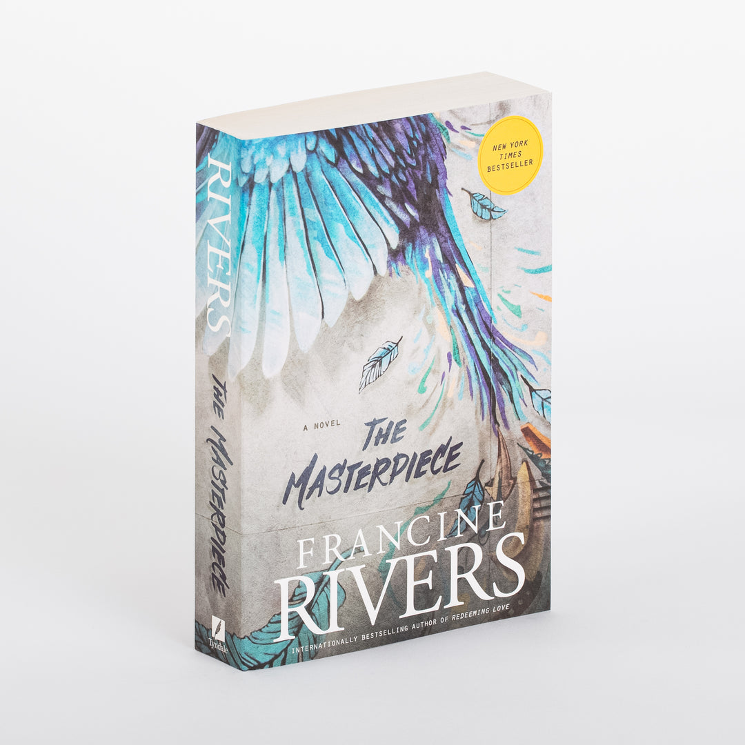 Angled view of the paperback The Masterpiece by Francine Rivers, showing the front cover and spine. A teal, turquoise, and purple painted bird wing sweeps down a gray, concrete-textured background with scattered feather illustrations and a yellow New York Times Bestseller sticker in the upper right. The title is in bold navy brush script above the author's name in large white capitals. The spine repeats RIVERS and The Masterpiece vertically.