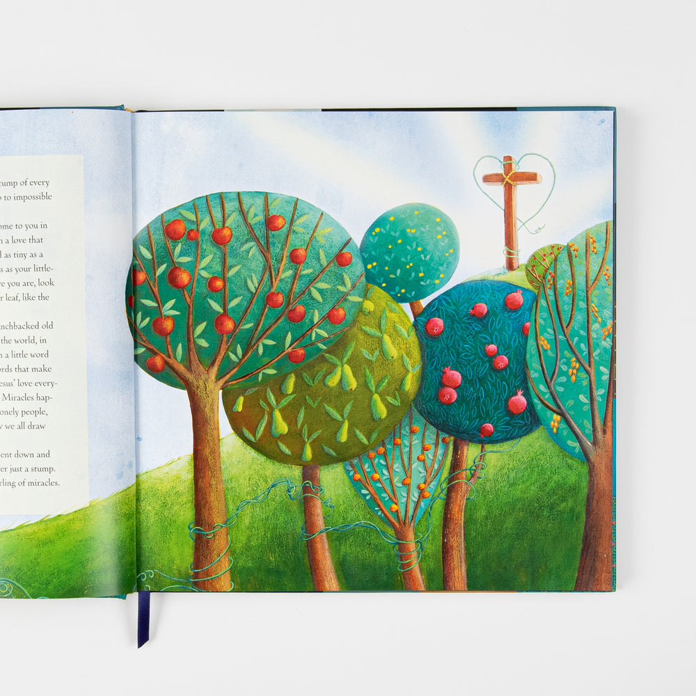 Open interior spread: left page shows devotional body text with a ribbon bookmark; right page is a full-page illustration of a hillside orchard with rounded, stylized fruit trees bearing apples, pears, and berries, and a wooden cross entwined with a glowing green vine heart against a bright sky.