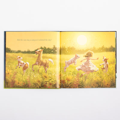 Illustrated book open to a page with children and animals in a field.