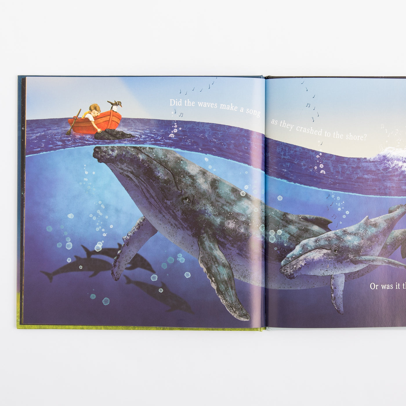 Open book showing a whale and a boat on an underwater scene