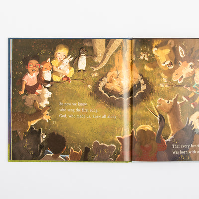 Open book with illustrations of children and animals around a campfire